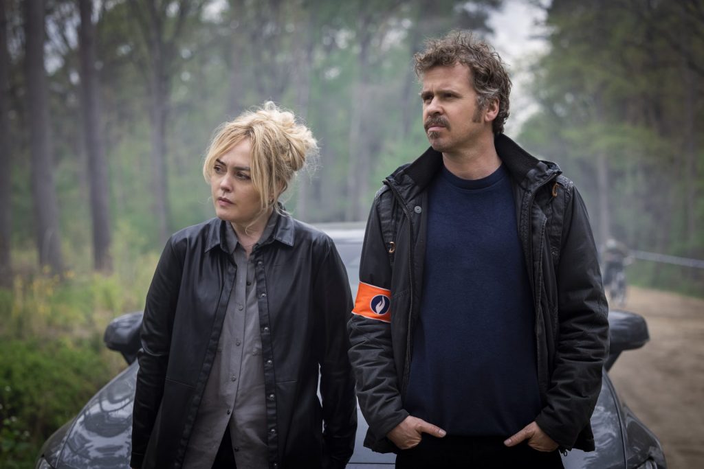 Female detective DS Emer Berry (Angeline Ball) and Inspector Christian De Jong (Wouter Hendrickx) lean on a car while contemplating a crime scene outdoors in Hidden Assets